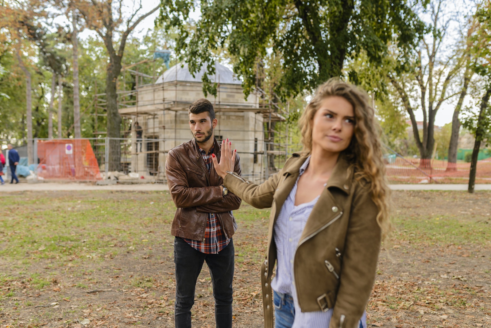 Man and Woman in Brown Leather Coat Standing on Brown Soil