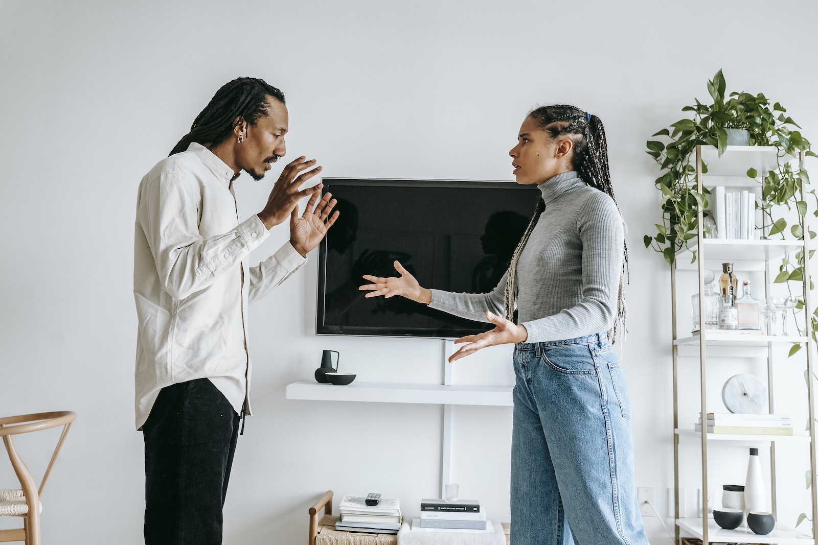 Annoyed young ethnic couple quarreling in cozy apartment